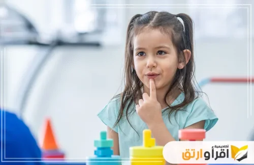 نرى طفلة صغيرة تجلس أمام مجموعة من الألعاب الملونة، وتبدو وكأنها تفكر أو تسأل عن شيء. أما بالنسبة أفضل علاج التأتأة عند الأطفال