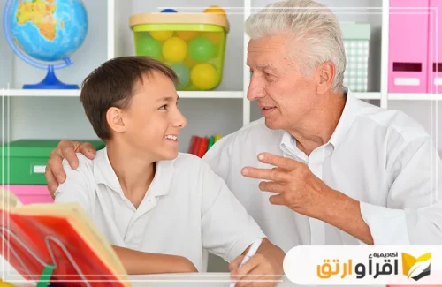 يظهر الجد وهو يوجه كلامه للطفل الذي يبدو منصتًا ومهتمًا بما يقوله. هذه اللحظات التفاعلية بين الأجيال لها دور كبير في تنمية مهارات الكلام عند الأطفال