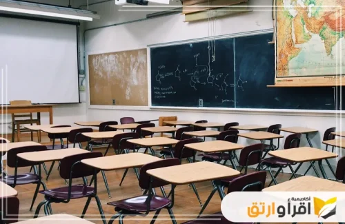 فصلاً دراسيًا مرتبًا مع طاولات وكراسي مخصصة للطلاب، والجدران مزينة بألواح تعليمية وخرائط. هذه البيئة التعليمية المثالية يمكن أن تتناسب مع برامج تعليمية متطورة للمدارس الخاصة
