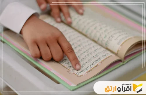 يد طفل تشير إلى آية في القرآن الكريم، مما يعكس تركيزه على تفسير القرآن الكريم بتدبر. هذه اللحظة تبرز أهمية تفسير القرآن الكريم وفهم معانيه