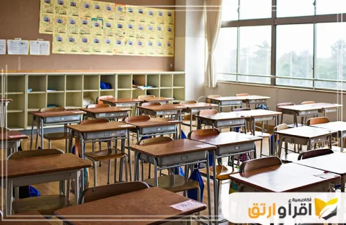 فصلًا دراسيًا خاليًا من الطلاب، مع صفوف من المقاعد الخشبية المنظمة. تعكس هذه البيئة الهادئة فرصة للمعلمين للتفكير في الأساليب الأفضل لدعم الطلاب، خاصة أولئك الذين يعانون من صعوبات التعلم عند الأطفال
