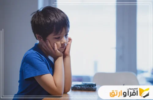الصورة تظهر طفلاً جالسًا على الطاولة ويبدو عليه الحزن والتفكير العميق، وهو يضع يديه على وجهه. هذه الصورة قد تعكس شعورًا بالقلق أو اخصائي نفسي