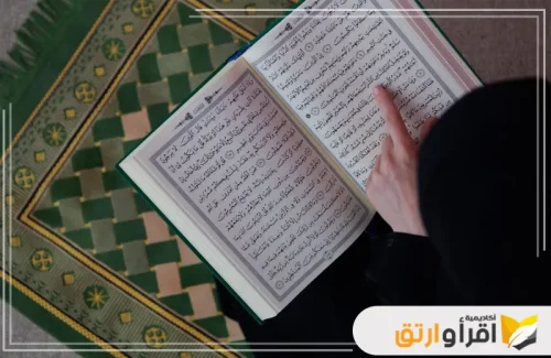 شخصًا يقرأ القرآن الكريم وهو يوجه إصبعه نحو الآيات. تجسّد هذه الصورة أهمية تعلم تجويد القرآن الكريم، حيث يظهر القارئ